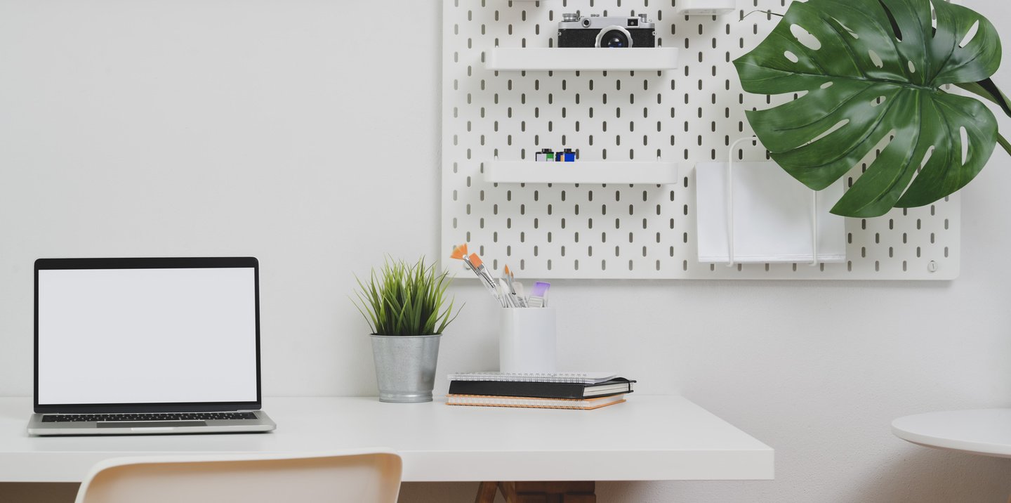 Open blank screen laptop computer with copy space and office decorations in minimal office room